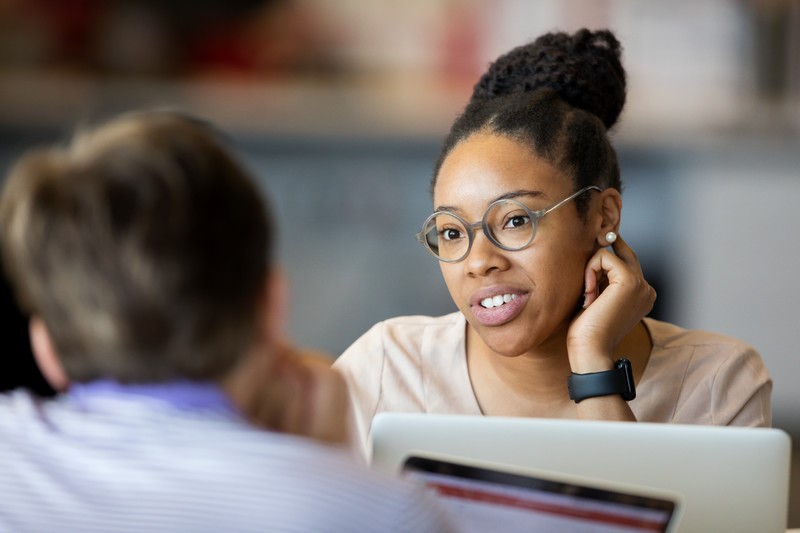 Women talking to someone overlooking her laptop